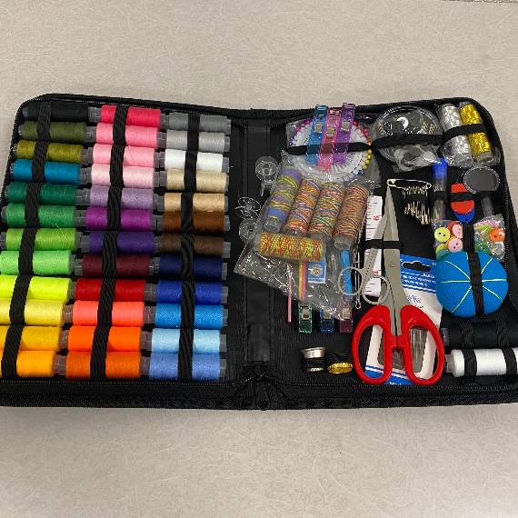 a sewing kit with multicolored thread, needles and pins