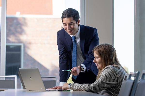 two people looking at data on a computer